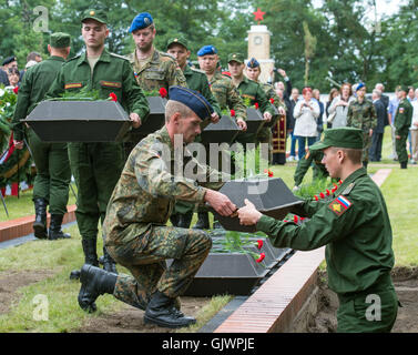 Lebus, Deutschland. 18. August 2016. Deutsche und russische Soldaten tragen kleine Särge mit den Überresten von sowjetischen Soldaten aus dem zweiten Weltkrieg, während ihre Grabstätte auf dem Soldatenfriedhof in Lebus, Deutschland, 18. August 2016. Die 35 Soldaten der Roten Armee starben in den schweren Kämpfen im Bereich Oderbruch im Frühjahr 1945. Die sterblichen Überreste wurden durch die Deutsche Kriegsgräberfürsorge letztes Jahr geborgen und können nun endlich zur Ruhe, mehr als 70 Jahre nach dem Ende des Krieges verlegt werden. Foto: PATRICK PLEUL/DPA/Alamy Live-Nachrichten Stockfoto