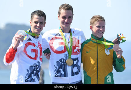 Rio De Janeiro, Brasilien. 18. August 2016. Goldmedaillengewinner Alistair Brownlee (C) ist Silbermedaillengewinner Jonathan Brownlee, beide aus Großbritannien, und Bronze-Medaillengewinner Henri Schoeman (R) von Südafrika bei der Siegerehrung nach der Herren Triathlon während der Rio 2016 Olympischen Spiele Fort Copacabana in Rio De Janeiro, Brasilien, 18. August 2016 flankiert. Foto: Sebastian Kahnert/Dpa/Alamy Live News Stockfoto