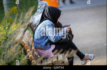 Berlin, Deutschland. 18. August 2016. Zwei Frauen mit Kopftuch sitzt auf einer Parkbank am Anhalter Bahnhof in Berlin, Deutschland, 18. August 2016. Foto: KAY NIETFELD/Dpa/Alamy Live News Stockfoto