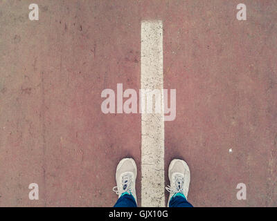 Zwischen der Fußgängerzonen Linie auf roten Bürgersteig steht Stockfoto
