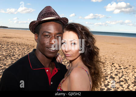 Junges Paar multikulturellen Mischlinge Kopf und Schultern Köpfe zusammen auf der Suche in Kamera am Strand romantische Gefühle Stockfoto
