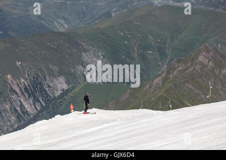 Mann auf Ski, tolle Aussicht vom Rand eines Berges am Hintertuxer Gletscher, Zillertal, Österreich an einem Sommertag Stockfoto