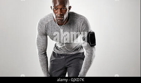 Jungen Mann bereit für den Betrieb auf grauem Hintergrund konzentriert. Muskulösen afrikanischen Männermodel in Sportbekleidung. Stockfoto