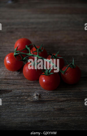 Cherry-Tomaten auf einem rustikalen Holztisch Stockfoto