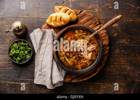 Traditionelle georgische Suppe Kharcho mit Fleisch und Reis auf hölzernen Hintergrund Stockfoto