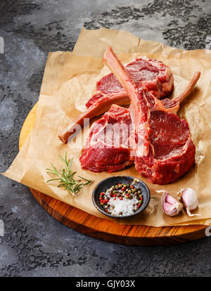 Rohes Frischfleisch Kalbfleisch Rippen Steak auf Knochen und Gewürze auf dunklem Hintergrund Stockfoto