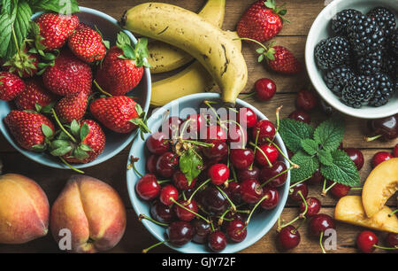 Sommer frische Früchte und Beeren-Vielfalt über hölzerne Kulisse, Draufsicht, horizontale Komposition Stockfoto