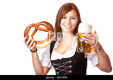 Frau im Dirndl hält Oktoberfest Bierkrug und Brezel Stockfoto