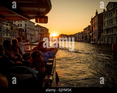 Passagiere auf dem Wasserbus oder Vaporetto auf dem Canal Grande bei Sonnenuntergang. in Venedig, Italien. Stockfoto