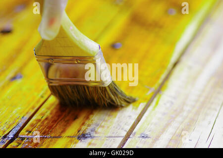 Pinsel auftragen einer Schicht der Schutzlack auf den Holztisch Stockfoto