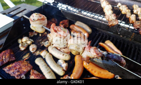 Gegrillte Champignon Skeewer vor anderen Leckereien auf einem Grill Stockfoto