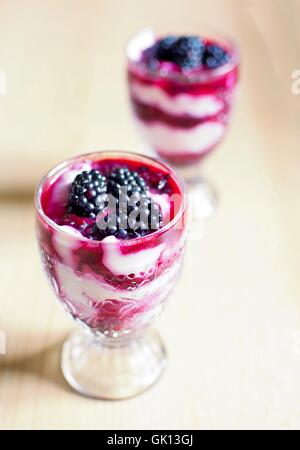 Tassen aus Glas mit Frischkäse Blackberry Desserts. Frische Brombeeren befinden sich oben auf die Desserts. Stockfoto