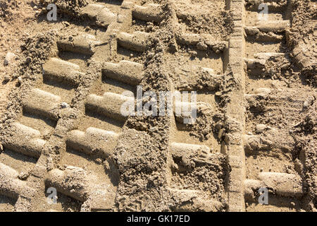 Hintergrund mit Fußspuren im Sand von schweren Maschinen Stockfoto