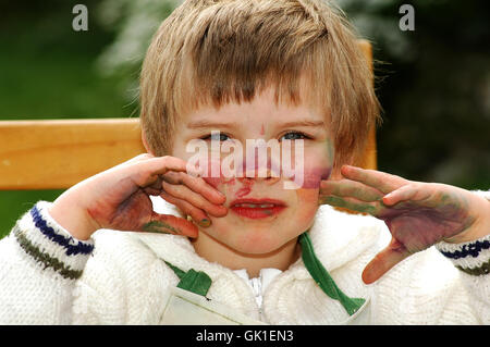 Kind zeigt ihre mucky Hände nach dem Malen Stockfoto