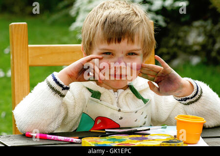 Kind zeigt ihre mucky Hände nach dem Malen Stockfoto