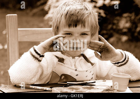 Kind zeigt ihre mucky Hände nach dem Malen Stockfoto