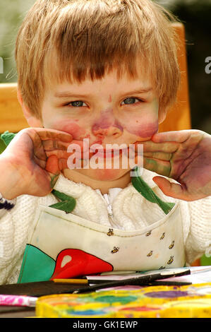 Kind zeigt ihre mucky Hände nach dem Malen Stockfoto