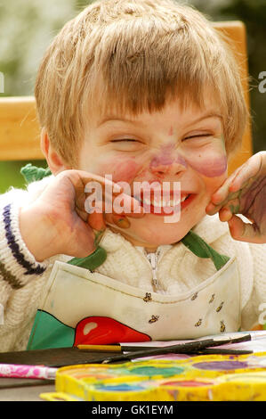 Kind zeigt ihre mucky Hände nach dem Malen Stockfoto