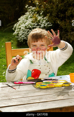 Kind im Garten zeigt eine mucky Hand nach dem Lackieren Stockfoto