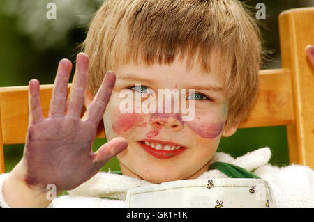 Kind zeigt ihre mucky Hände nach dem Malen Stockfoto