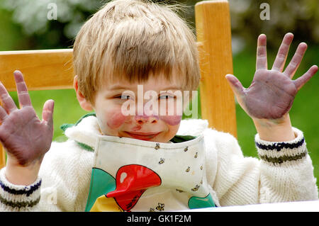 Kind zeigt ihre mucky Hände nach dem Malen Stockfoto