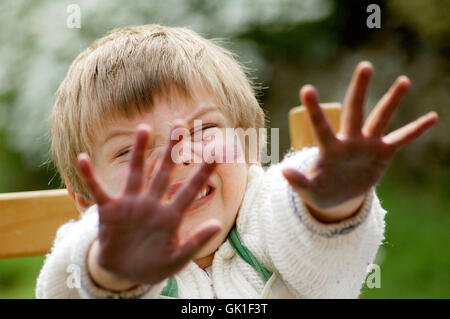 Kind zeigt ihre mucky Hände nach dem Malen Stockfoto