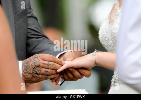 Platzierung Ehering an der Hand seiner Braut Bräutigam. Hochzeit im Freien. Stockfoto