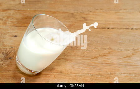 Glas Milch sind fallende Bewegung nach unten auf einem Holztisch Stockfoto
