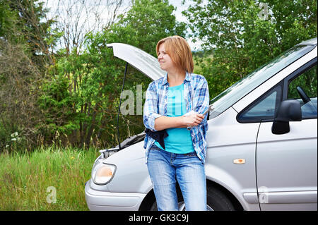 Frau wartet, Hilfe in der Nähe von kaputten Auto Landschaft unterwegs Stockfoto