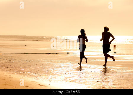 Sport-paar jogging am Strand Stockfoto
