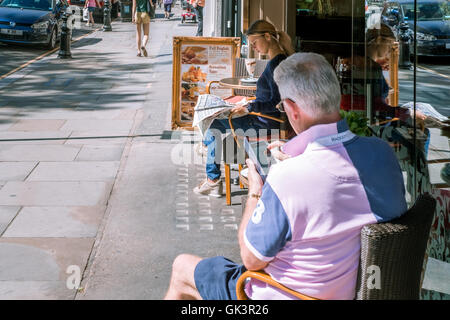 Eine junge Frau und ein älterer Mann, genießen, Essen im Freien in London an einem schönen sonnigen Tag 8. August 2016 Stockfoto