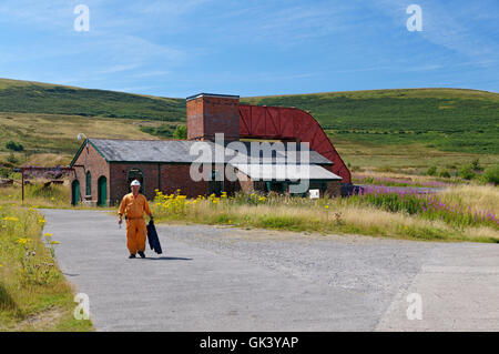 Bergmann mit dem Fan-Haus im Hintergrund, Big Pit Bergbau-Museum, Blaenavon, Torfaen, South Wales, UK. Stockfoto