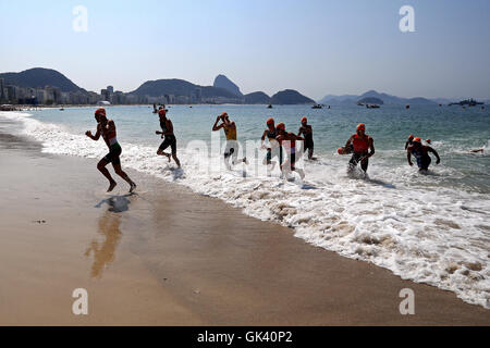 Athleten verlassen das Wasser, während die Männer Triathlon am Fort Copacabana am dreizehnten Tag der Olympischen Spiele in Rio, Brasilien. Stockfoto