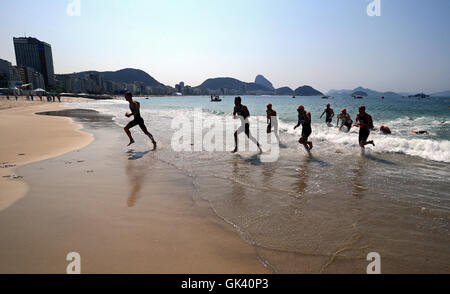 Athleten verlassen das Wasser, während die Männer Triathlon am Fort Copacabana am dreizehnten Tag der Olympischen Spiele in Rio, Brasilien. Stockfoto