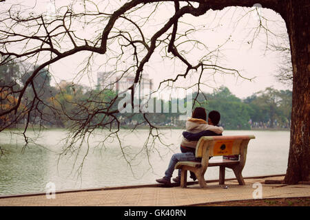 Hanoi, Vietnam - 10. März 2012: das Paar sitzen auf der Bank am Hoan-Kiem-See Stockfoto