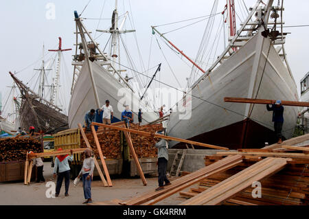 2005, Jakarta, Java, Indonesien---Holz geladen und Entladen von Bugis Schoner in Jakartas Sundra Kelapa Dock. Die schoo Stockfoto