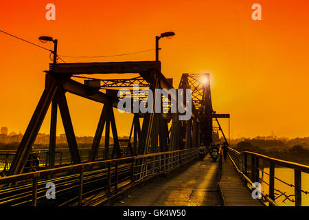 Hanoi, Vietnam - 18. November 2012: Menschen gehen nach Hause in den Sonnenuntergang am Long Bien-Brücke Stockfoto