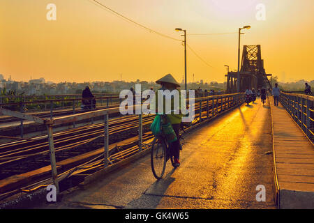 Hanoi, Vietnam - 18. November 2012: die Frau und andere Menschen nach Hause gehen, in den Sonnenuntergang am Long Bien-Brücke Stockfoto