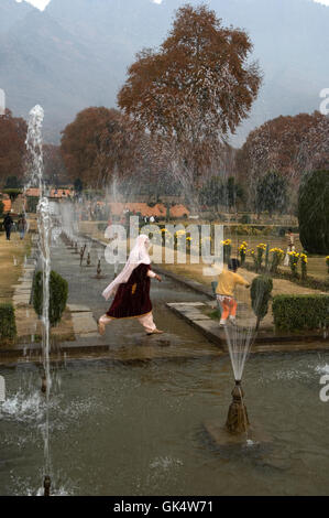 2009, Srinagar, Indien---Besucher zu Fuß durch den Brunnen der Nishat Bagh in Kaschmir, Indien. Nishat Bagh wurde auf den Osten gebaut. Stockfoto