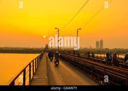 Hanoi, Vietnam - 18. November 2012: Menschen gehen nach Hause in den Sonnenuntergang am Long Bien-Brücke Stockfoto