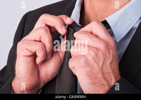 junger Geschäftsmann seine Krawatte anpassen Stockfoto