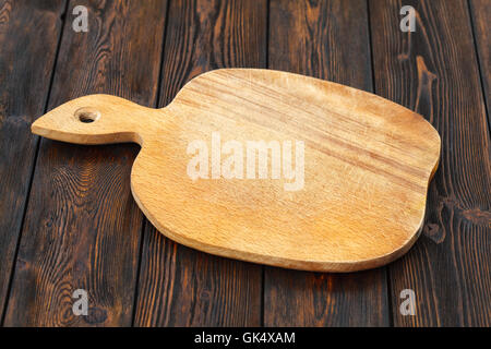 Leere Schneidebrett auf einem dunklen Holztisch Stockfoto