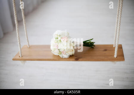 Schöne weiße Pfingstrose Hochzeit Bouquet auf Schaukel. Ehe-Konzept Stockfoto