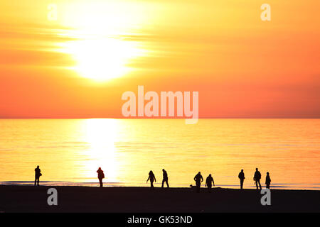 Menschen am Strand bei Sonnenuntergang Stockfoto