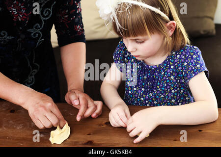 Kochen mit Kindern. Kleines Mädchen gelehnt wie Manti (Zentralasien Knödel) zu machen. Stockfoto