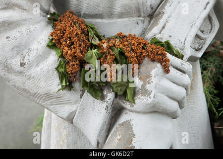 Verblasst lila Blumen auf das Sowjetische Ehrenmal auf dem Friedhof der Stadt in Roudnice nad Labem in Mittelböhmen, Tschechien. Stockfoto