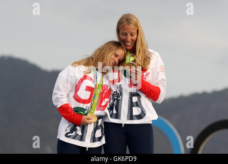 Great Britain Hannah Mills und Saskia Clark (rechts) auf dem Podium mit ihren Goldmedaillen von 470 Frauenlauf in der Marina da Gloria am dreizehnten Tag der Olympischen Spiele in Rio, Brasilien zu feiern. Stockfoto