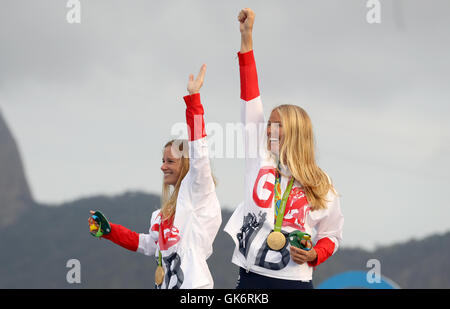 Great Britain Hannah Mills und Saskia Clark (rechts) auf dem Podium mit ihren Goldmedaillen von 470 Frauenlauf in der Marina da Gloria am dreizehnten Tag der Olympischen Spiele in Rio, Brasilien zu feiern. Stockfoto