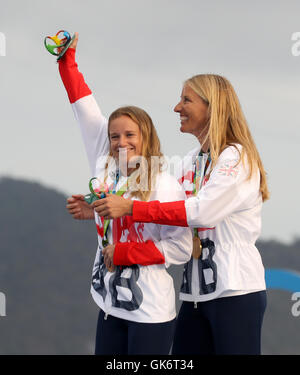 Great Britain Hannah Mills und Saskia Clark (rechts) auf dem Podium mit ihren Goldmedaillen von 470 Frauenlauf in der Marina da Gloria am dreizehnten Tag der Olympischen Spiele in Rio, Brasilien zu feiern. Stockfoto