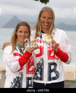 Great Britain Hannah Mills und Saskia Clark (rechts) auf dem Podium mit ihren Goldmedaillen von 470 Frauenlauf in der Marina da Gloria am dreizehnten Tag der Olympischen Spiele in Rio, Brasilien zu feiern. Stockfoto